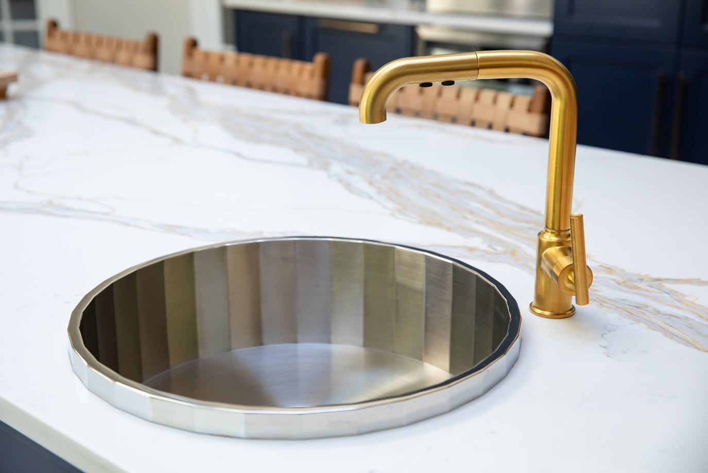 A faceted stainless steel prep sink pairs effortlessly with a satin gold hex pull-down faucet.  The custom 1-1/4